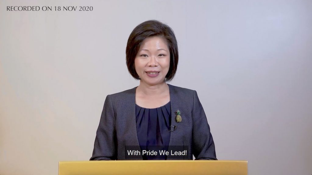 Minister Sim Ann looking into the camera while giving her speech.