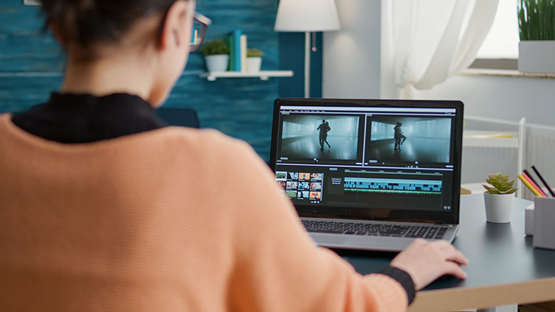 A person editing a video on a laptop