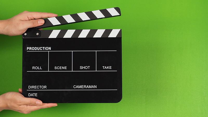 Hand holds empty filmmaking clapperboard for video production