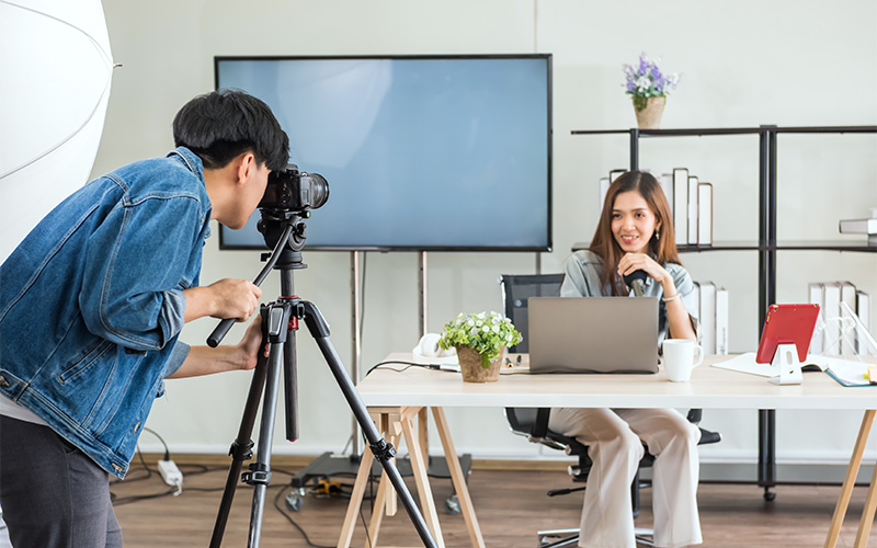 Videographer filming a woman for an ESG reporting video shoot.