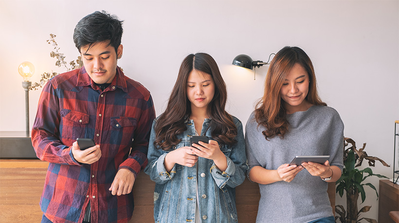 Young people consuming short-form video content on their phones.