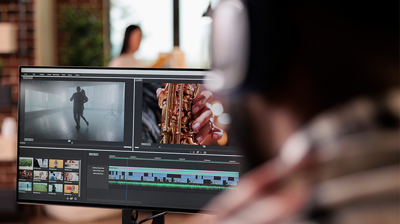 Person editing video on computer with preview windows showing dancer and saxophone player in timeline view.
