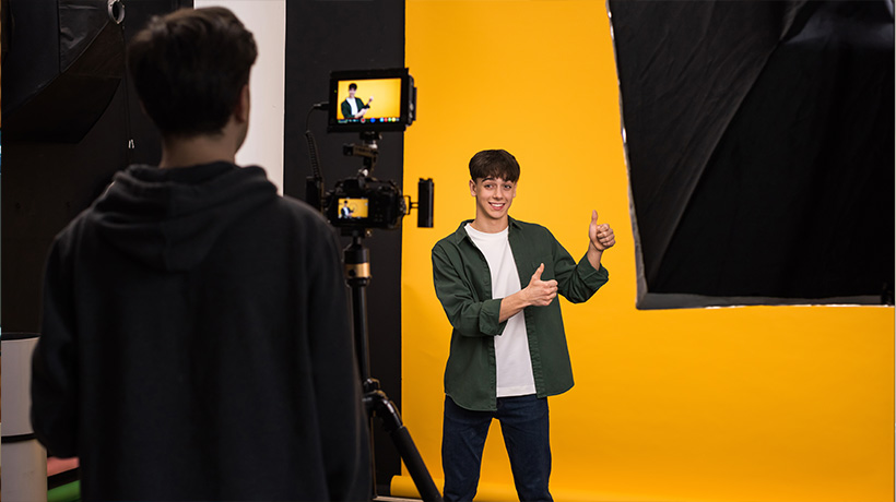 A young man giving a thumbs up during a professional studio filming session