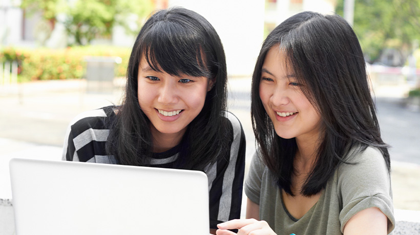 International students engaging with university digital content on campus.